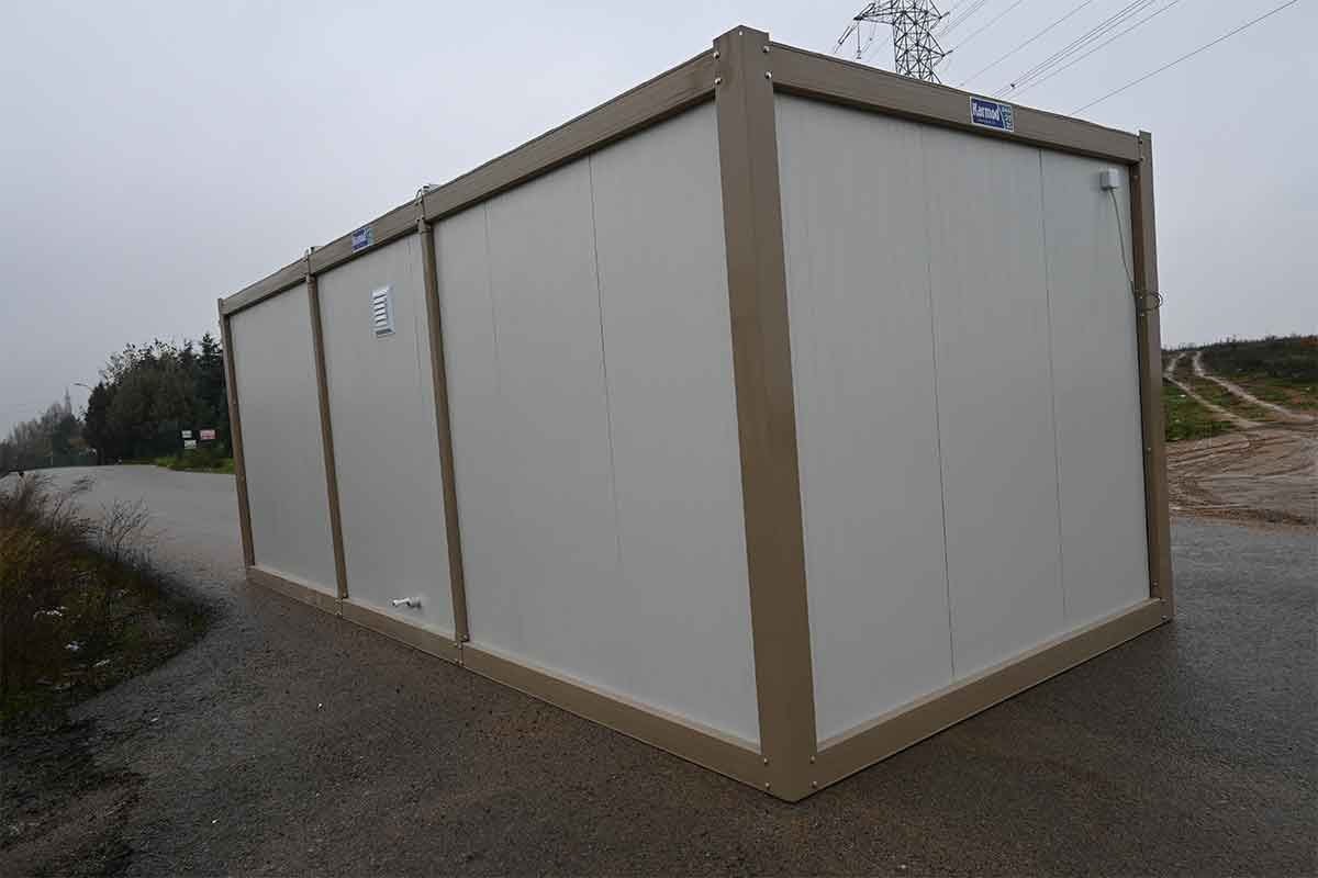 Blank side elevation of a standard container unit on a gravel yard, ventilated but unglazed.