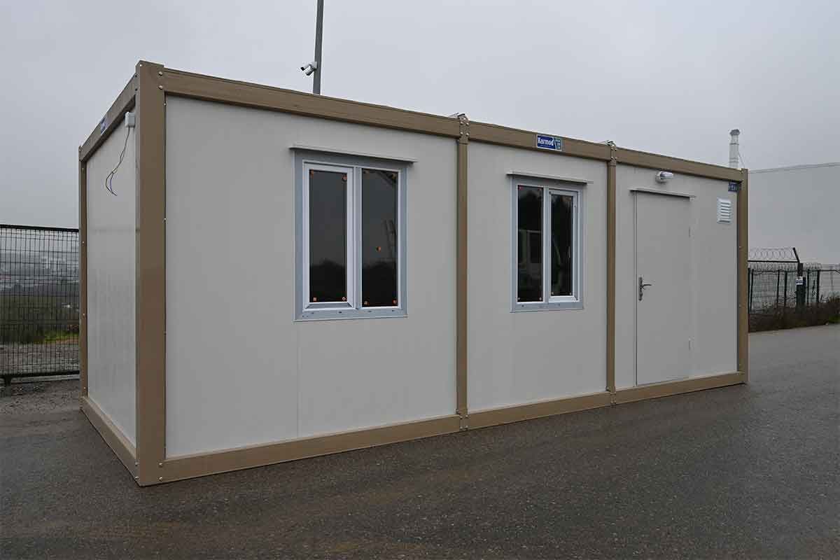 Standard container unit with the personnel door in the end bay and two windows along the long elevation.