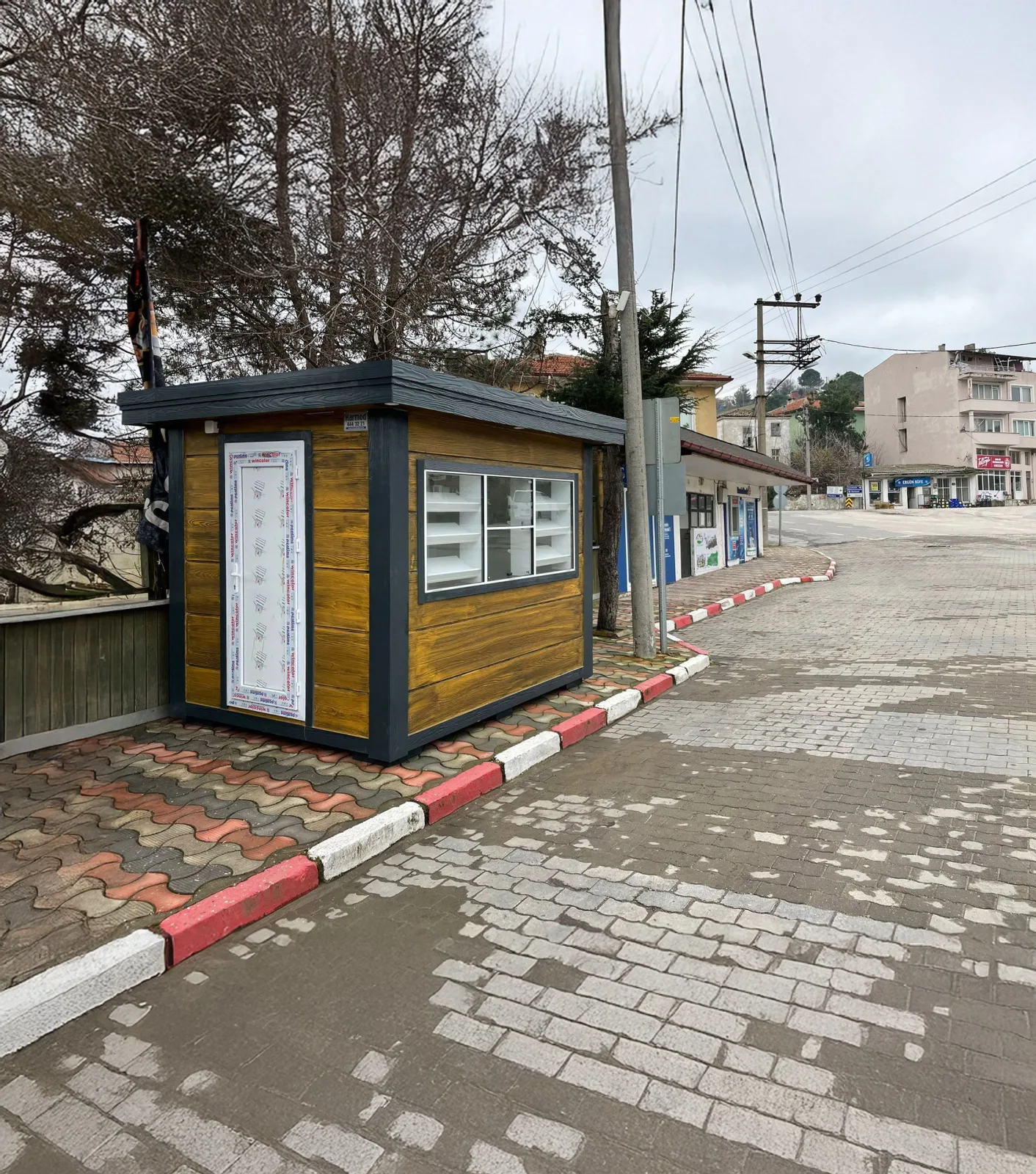 Metro City kiosk clad in timber-effect panels with a glazed display window and bakery shelving, sited on a town pavement.