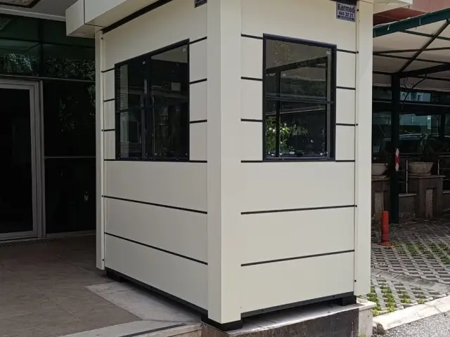 KompoCity composite gatehouse at an office door, with a deep roof overhang casting shade over the approach
