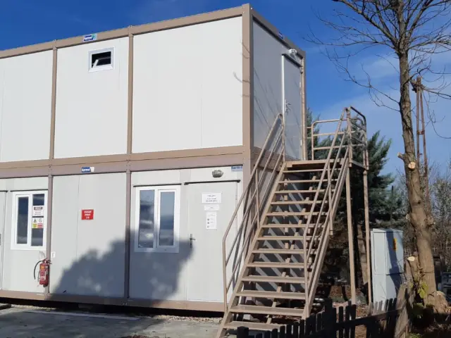 Two-storey container office block with an external staircase serving the upper floor