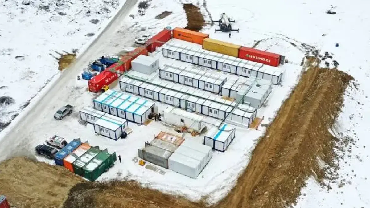 Container site camp in snow seen from the air, with office and welfare units around a central yard