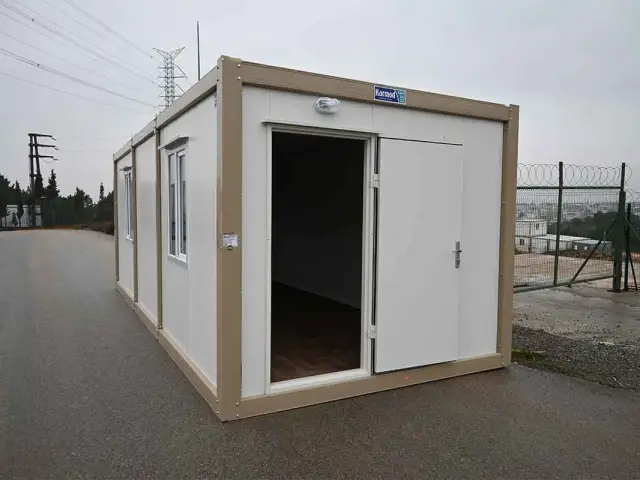 Container unit with its door open on delivery, showing the wood-effect floor inside