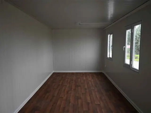 Inside a standard container unit as delivered, with lined walls, a fitted floor and glazed windows