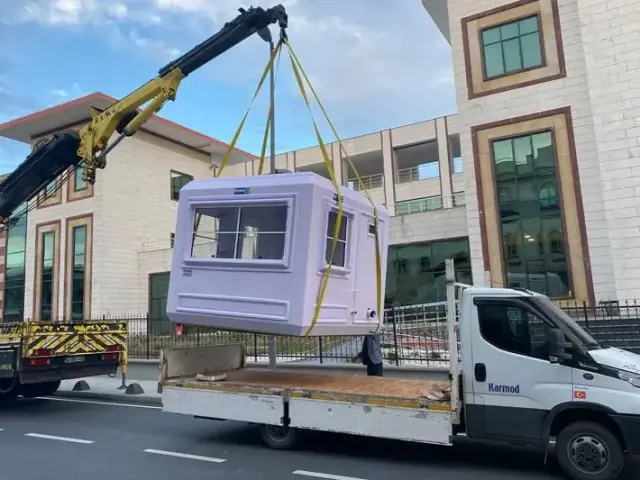 Lilac GRP kiosk lifted off a delivery lorry on straps by a truck-mounted crane