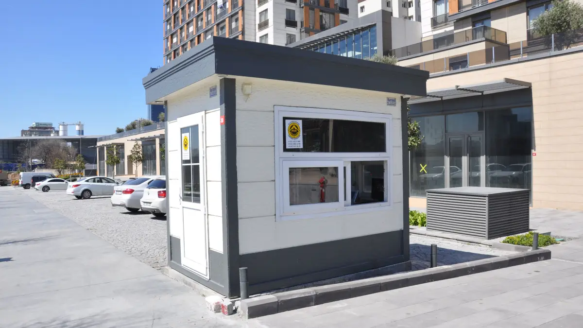 MetroCity security cabin on a paved forecourt in front of residential tower blocks