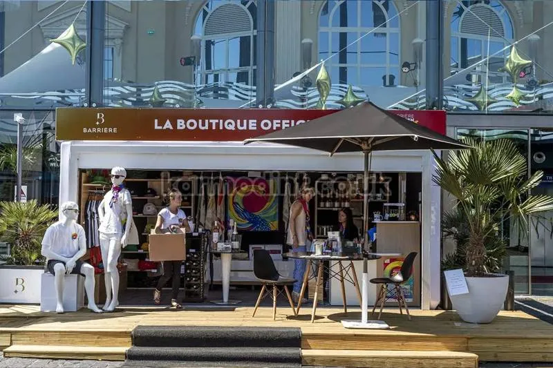 White pop-up boutique unit for Barrière on a timber deck with a glazed front