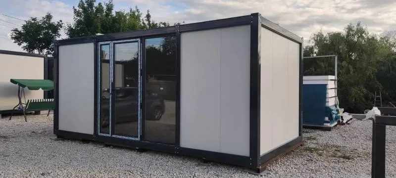Container unit with a dark frame and full-height glazed double doors