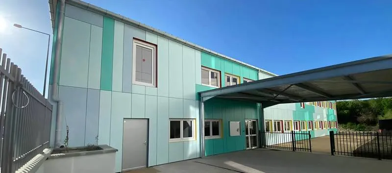 Two-storey modular building with mint and green cladding and a covered entrance walkway